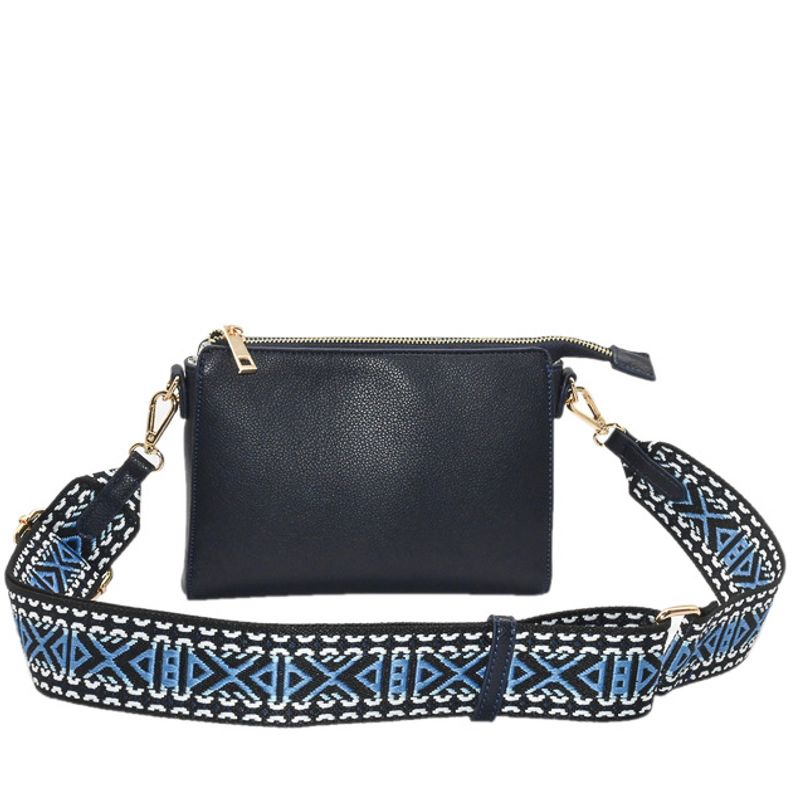 Marinblå väska clutch med mönstrad axelrem